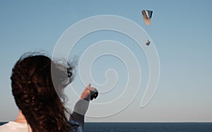 Woman points to the flying paraglider. Paraglider soars in the sky. Girl looks at a paraglider in the sky