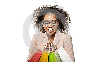 Woman points to something with her finger. African American girl with shopping bags. Discounts, sales and promotions