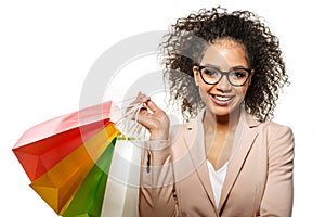 Woman points to something with her finger. African American girl with shopping bags. Discounts, sales and promotions