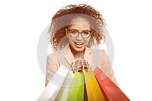 Woman points to something with her finger. African American girl with shopping bags. Discounts, sales and promotions