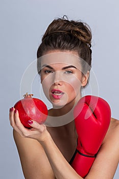 Woman with pomegranate and boxing glove