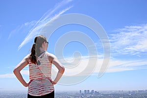 Woman with ponytail looking at city skyline