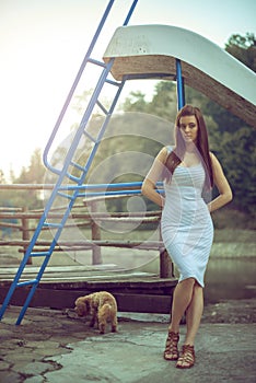 Woman with poodle dog at mountain lake.