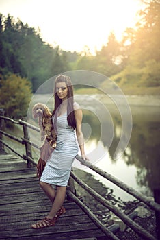 Woman with poodle dog at mountain lake.