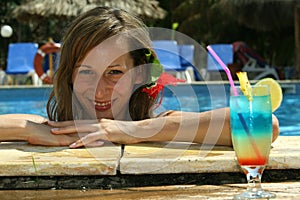 Woman in pool with cocktail