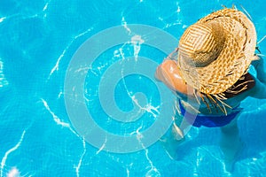 Woman in a pool with hat relaxed and rested