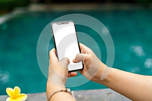 Woman in the pool holding both hands phone with an screen and modern frame less design
