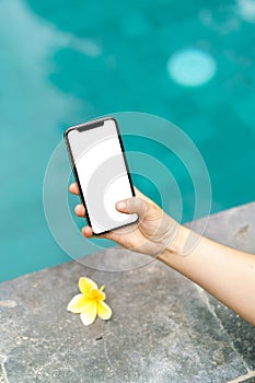 Woman in the pool holding phone with an screen and modern frame less design