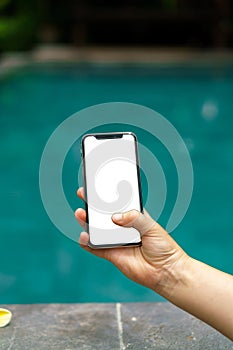 Woman in the pool holding phone with an screen and modern frame less design