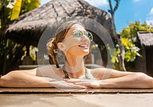 Woman in the pool of hotel resort in the tropics