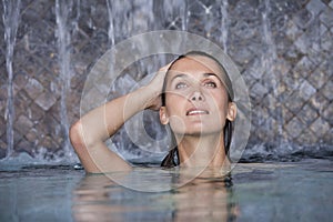 Woman in a pool under waterfalls