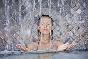 Woman in a pool under waterfalls