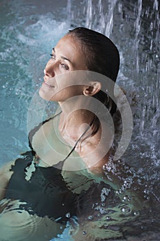 Woman in a pool under waterfalls