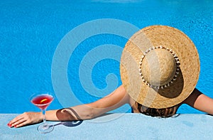 Woman at poolside with cosmopolitan cocktail