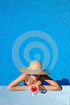 Woman at poolside with cosmopolitan cocktail