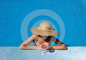 Woman at poolside with cosmopolitan cocktail