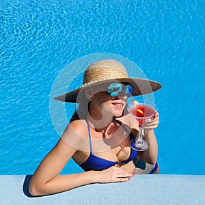 Woman at poolside with cosmopolitan cocktail