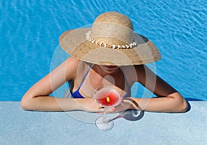 Woman at poolside with cosmopolitan cocktail