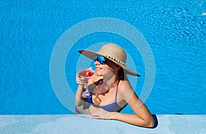 Woman at poolside with cosmopolitan cocktail