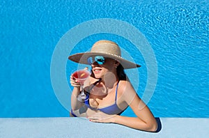 Woman at poolside with cosmopolitan cocktail