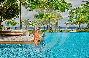 Woman by poolside. Resort swimming pool at Seychelles