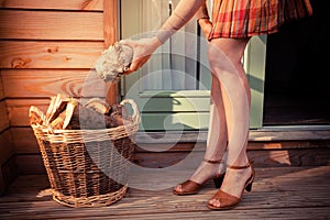 Woman on porch getting logs for firewood