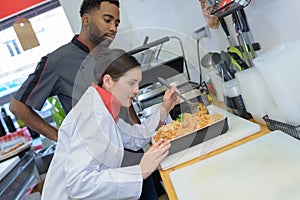 Woman pork butcher serving sausages to customer