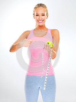 Woman, portrait and apple with measuring tape for healthy weight loss or hungry, wellness or white background. Female