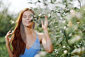 Woman portrait beautifully smiling with teeth spring happiness in nature against a green tree hand touch tenderness