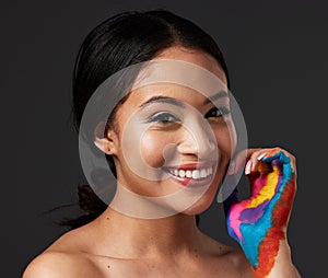 Woman, portrait and beauty smile with rainbow paint hand or art on and face in studio. Creative skin and makeup on