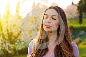 Woman portrait breathing deep fresh air with nature in background