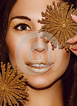 Woman portrait brunette with Christmas decorations gold snowflakes.