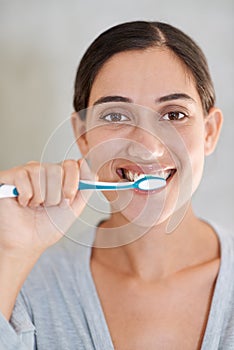 Woman, portrait and brushing teeth with smile in home for health, wellness or care for breath in morning. Girl, person