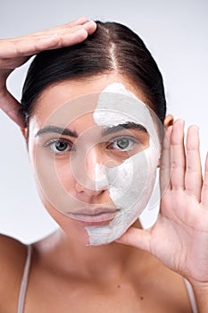 Woman, portrait and clay mask in studio, beauty and half skincare to exfoliate on white background. Female person, half photo
