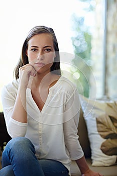 Woman, portrait and confident in home on sofa with serious face for pensive mood or quiet contemplation and inner