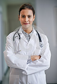 Woman, portrait and doctor with arms crossed in hospital, clinic and wellness facility with confidence in medical career