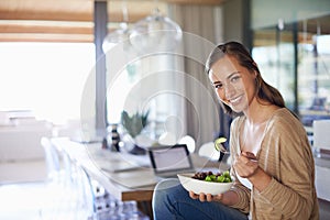 Woman, portrait and eating a salad in home, green vegetables and vegan diet for nutrition. Female person, healthy meal