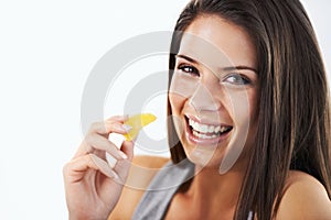 Woman, portrait and eating tangerine in studio for nutrition, healthy vegan diet or clean detox on white background