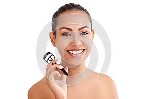 Woman, portrait and eyelash curler in studio for beauty treatment or makeup, white background or mockup space. Female