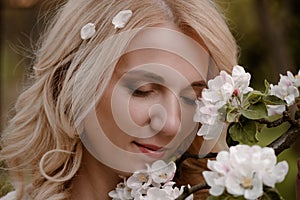 Woman portrait with eyes closed enjoying flowering spring