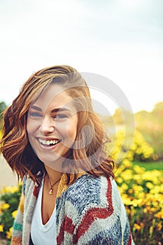 Woman, portrait and flowers with smile in nature or autumn environment, countryside or outdoor. Female person, face and