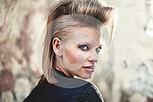 Woman, portrait and happy in edgy fashion with punk rock hairstyle, attitude and cool in funky clothes by wall. Person