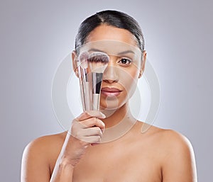 Woman, portrait and makeup brush or beauty tools for skin care model, grey background or wellness. Female person, face