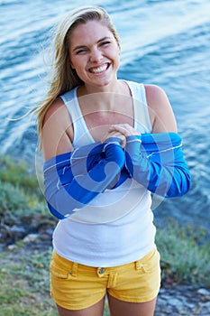 Woman, portrait and smile with wetsuit, ready and happiness for water sports by river, lake or dam. Girl, outdoor and