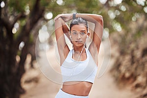 Woman, portrait and stretching and earphone in nature, runner and body wellness or health in forest. Sports, exercise