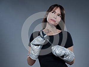 Woman Portrait thinking holding kitchen utensils