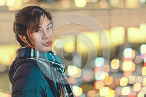 Woman portrait in winter clothing at night at Sendai station Japan with Bokeh light of Taxi stand in the background