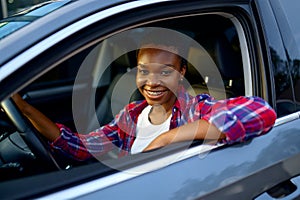 Woman poses in shinning car, auto wash station