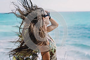 Woman posing on a beach with her hair blowing in the wind