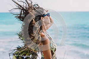 Woman posing on a beach with her hair blowing in the wind